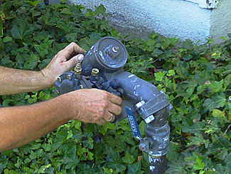 Surprise sprinkler repair technician checks backflow prevention device